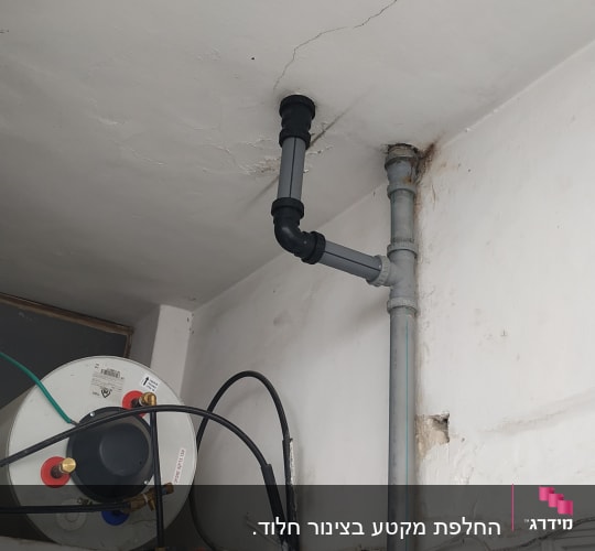 צינור פלסטיק אפור מחובר לתקרה עם חיבורים שחורים